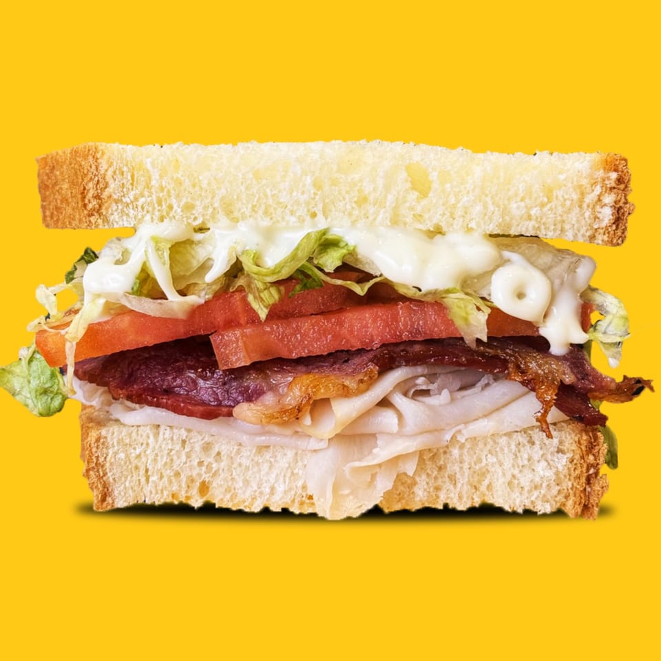 A Jay's Deli sandwich with turkey, bacon, lettuce, tomato, and mayonnaise on white bread.